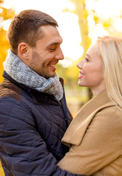 Pareja sonriente abrazándose en el parque de otoño — Foto de Stock