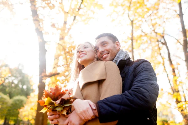 Coppia sorridente che si abbraccia nel parco autunnale — Foto Stock