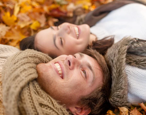 Крупный план улыбающейся пары, лежащей в осеннем парке — стоковое фото