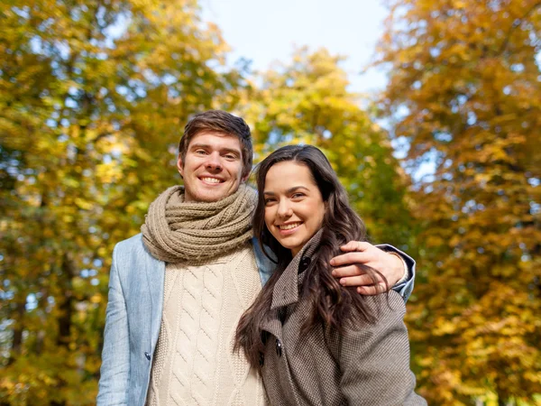 Casal sorridente abraçando no parque de outono — Fotografia de Stock