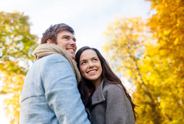 Smiling couple hugging in autumn park — Stock Photo, Image