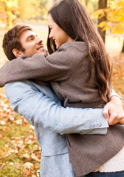 Glimlachend paar knuffelen in de herfst park — Stockfoto