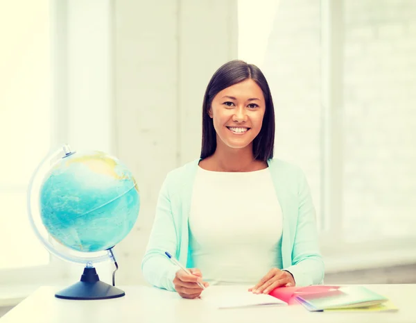Teacher with globe and notepad at school — Stock Photo, Image