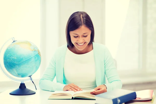 Insegnante con globo e libro a scuola — Foto Stock