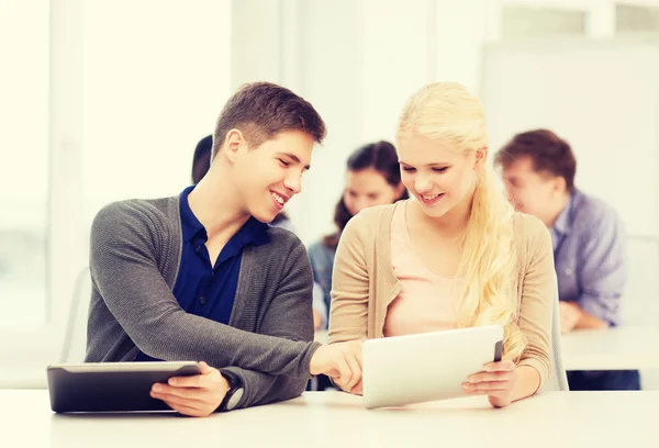 Studenten kijken naar tablet pc in lezing op school — Stockfoto