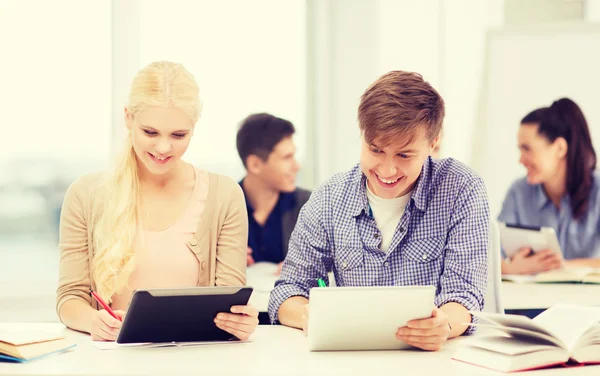 Dos estudiantes sonrientes con tablet PC en la escuela —  Fotos de Stock