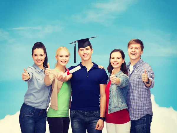 Grupp studenter med diplomet visar tummen — Stockfoto