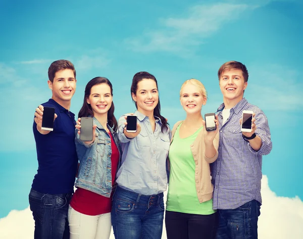 Students showing blank smartphones screens — Stockfoto