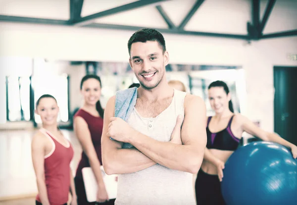 Sonriente hombre de pie frente al grupo en el gimnasio — Foto de Stock