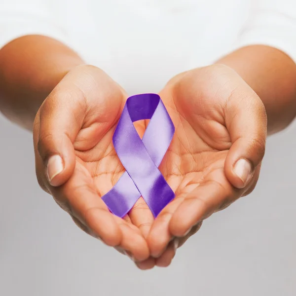 Hands holding purple awareness ribbon — Stock Photo, Image