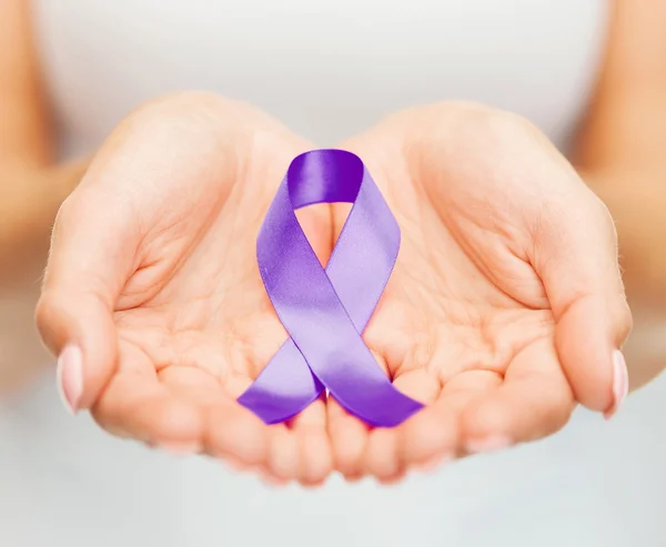 Hands holding purple awareness ribbon — Stock Photo, Image