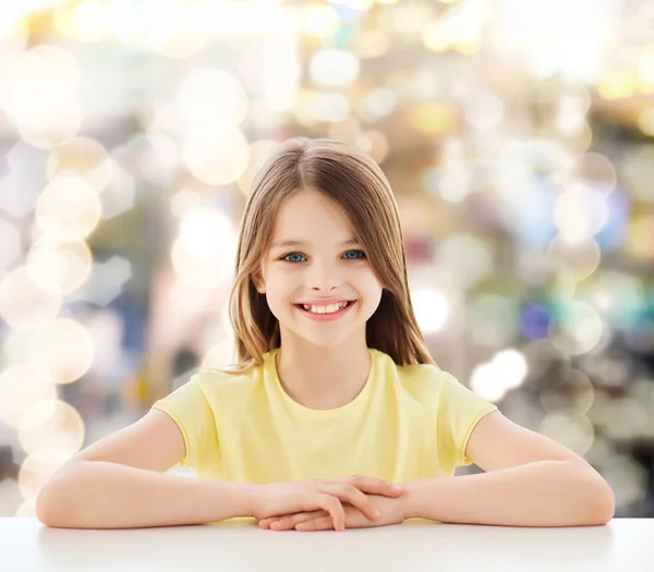 Beautiful little girl sitting at table — Stock Photo, Image