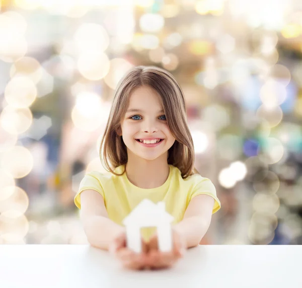 Beautiful little girl holding paper house cutout — Stock Photo, Image