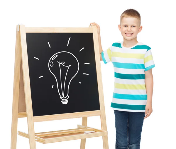 Smiling little boy with blank blackboard — Stock Photo, Image