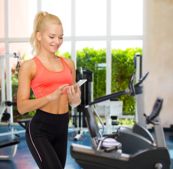 Lachende sportieve vrouw met smartphone — Stockfoto