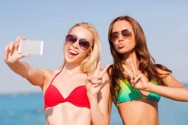 Dwie kobiety uśmiechający się co selfie na plaży — Zdjęcie stockowe