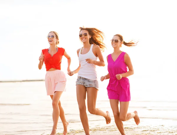 Группа улыбающихся женщин бегает по пляжу — стоковое фото