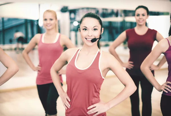 Grupo de personas sonrientes haciendo ejercicio en el gimnasio — Foto de Stock