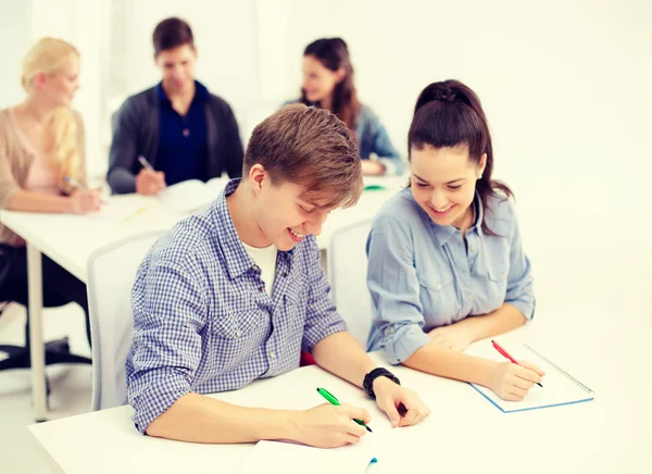 Studenti sorridenti con quaderni a scuola — Foto Stock