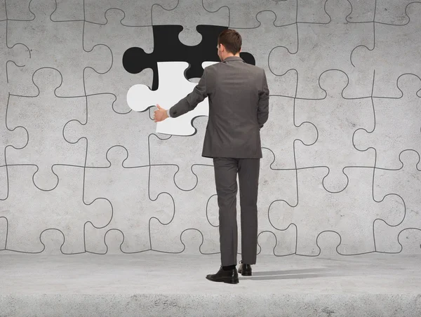 Businessman in suit setting piece of puzzle — Stock Photo, Image