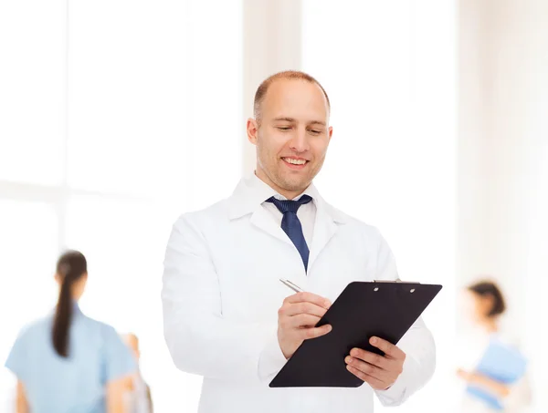 Médico varón sonriente con portapapeles — Foto de Stock