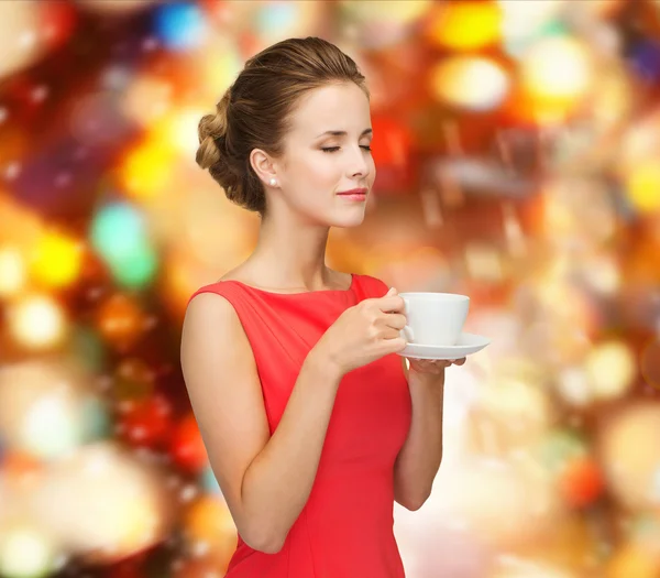 Donna sorridente in abito rosso con tazza di caffè — Foto Stock