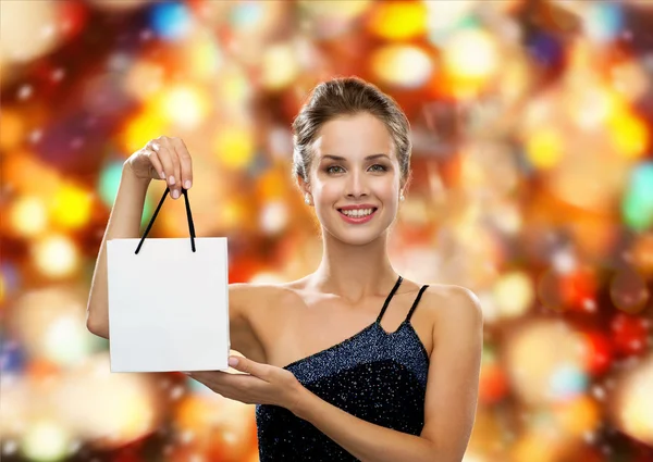 Mulher sorrindo com saco de compras em branco branco — Fotografia de Stock