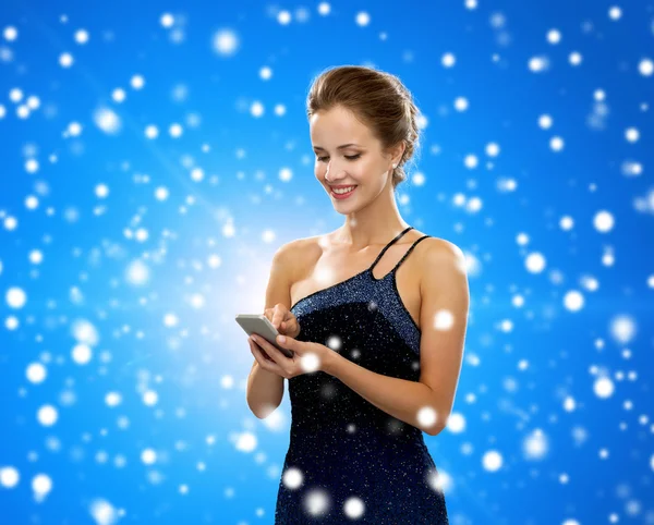 Mulher sorridente em vestido de noite com smartphone — Fotografia de Stock