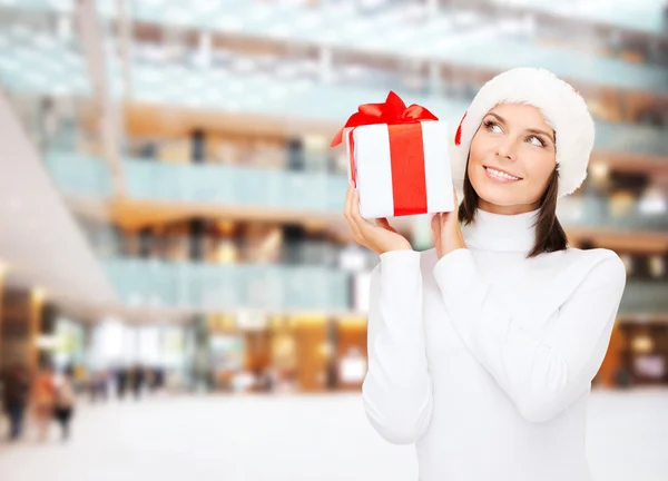 Mujer sonriente en sombrero de ayudante de santa con caja de regalo —  Fotos de Stock