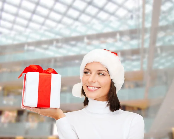 Mujer sonriente en sombrero de ayudante de santa con caja de regalo — Foto de Stock