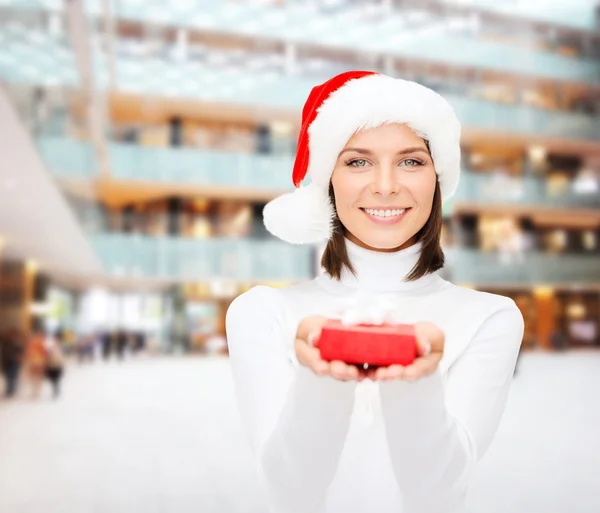 Mujer sonriente en sombrero de ayudante de santa con caja de regalo — Foto de Stock