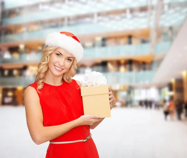 Mujer sonriente en sombrero de ayudante de santa con caja de regalo — Foto de Stock