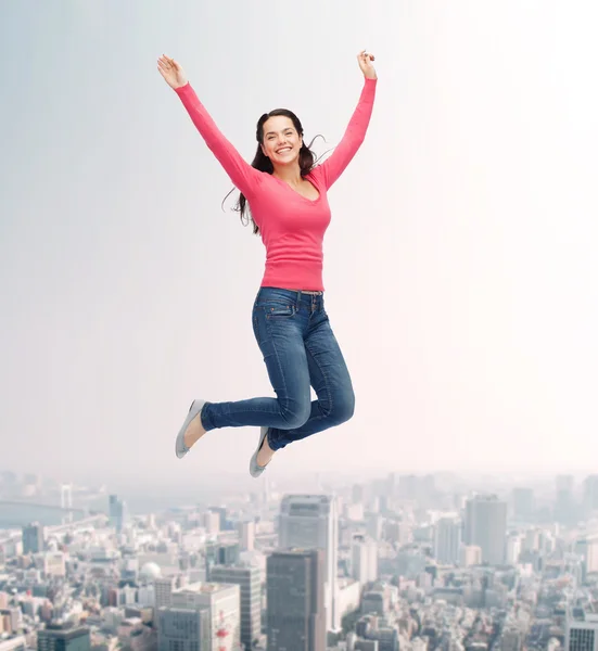 Lächelnde junge Frau springt in die Luft — Stockfoto