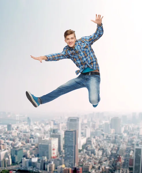 Smiling young man jumping in air — Stock Photo, Image