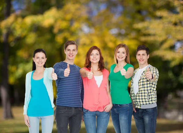 Группа улыбающихся студентов, показывающих большие пальцы вверх — стоковое фото