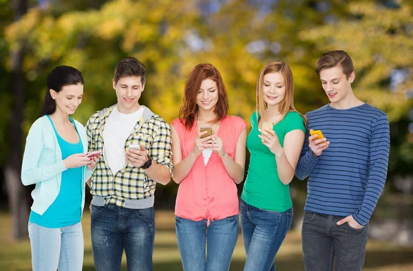 Studenti sorridenti con smartphone — Foto Stock