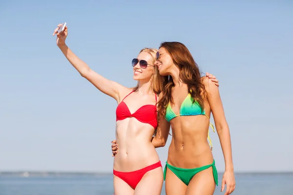 Due donne sorridenti che fanno selfie sulla spiaggia — Foto Stock