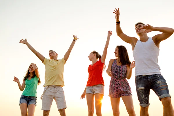 Smiling friends dancing on summer beach Royalty Free Stock Images