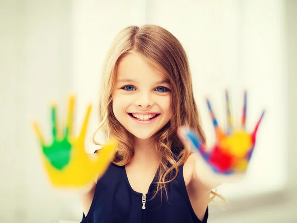 Усміхнена дівчина показує розфарбовані руки — стокове фото