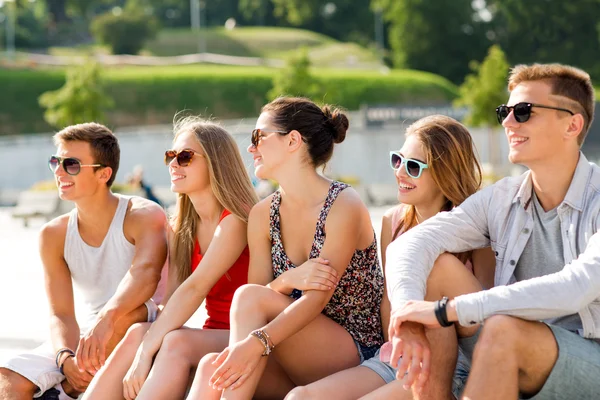 Gruppe lächelnder Freunde sitzt auf dem Stadtplatz — Stockfoto