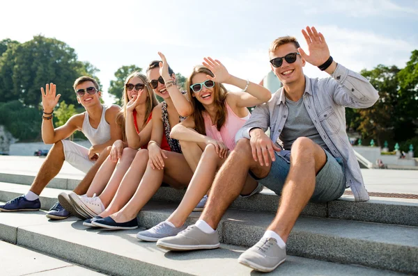 Grupo de amigos sonriendo sentados en la calle de la ciudad —  Fotos de Stock