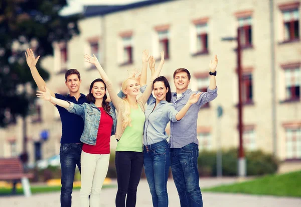 Group of smiling students waving hands — Stock Photo, Image