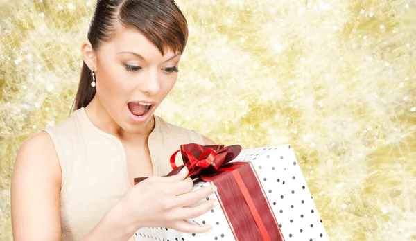 Mujer sonriente en vestido rojo con caja de regalo — Foto de Stock