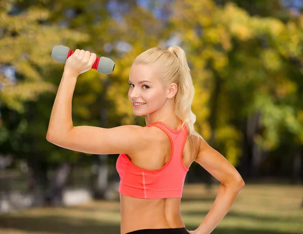 Jovem mulher esportiva com halteres leves — Fotografia de Stock