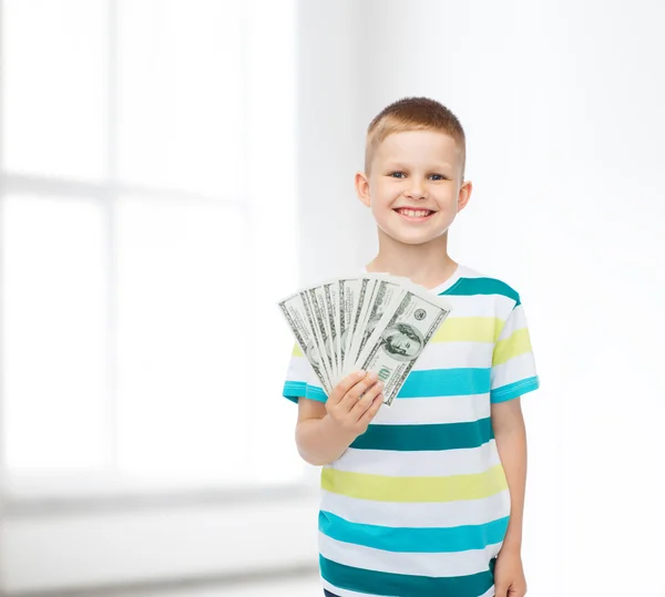 Sorrindo menino segurando dinheiro em dinheiro dólar em sua mão — Fotografia de Stock