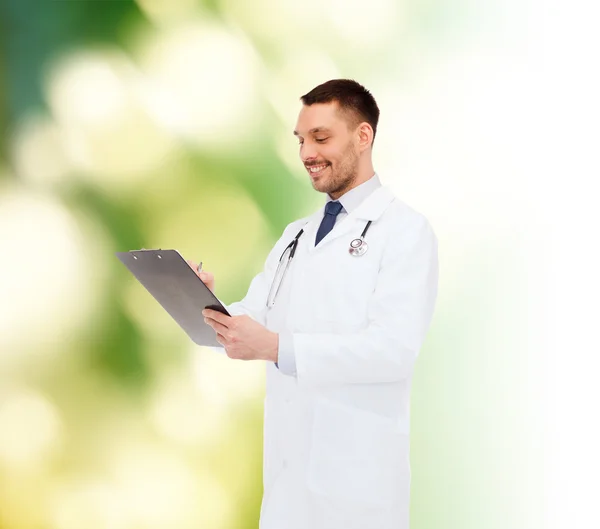 Médecin masculin souriant avec presse-papiers et stéthoscope — Photo