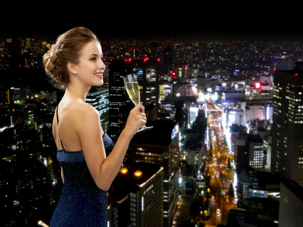 Sonriente mujer sosteniendo un vaso de vino espumoso — Foto de Stock