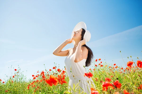 Giovane donna sorridente in cappello di paglia sul campo di papavero — Foto Stock