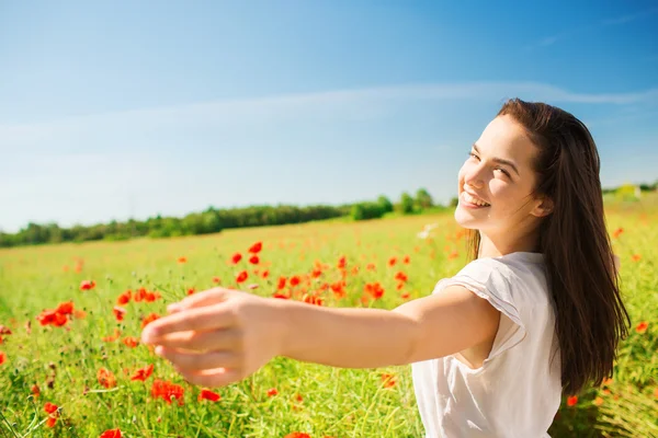 Souriant jeune femme sur champ de pavot — Photo