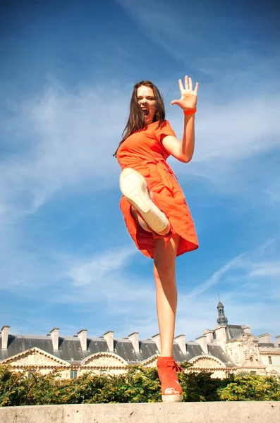 Mulher em vestido laranja andando na rua — Fotografia de Stock